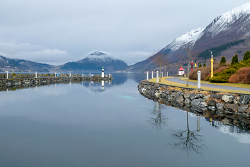 Image showing Serene Winter Morning at a Snow-Dusted Lakeside With Reflective 