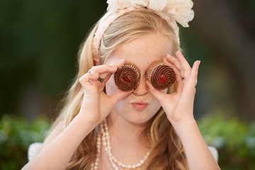 Image showing Child, cupcakes and eyes for fun play or dress up in garden for birthday celebration, dessert or event. Female person, fancy accessories and funny face with sweet food or outdoor, quirky or humor