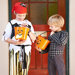 Image showing Halloween, candy and door with children in costume on porch for trick or treat celebration together. Friends, food and sweets with young boy kids in fancy dress for spooky holiday or vacation