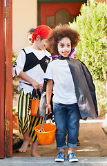 Image showing Children, halloween and trick or treat outdoor in costume for celebrate, holiday and spooky outfit or tradition. Kids, event and autumn role play with basket, fancy dress or happy in garden of home