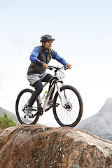 Image showing Sports, athlete and a man on a bike on the mountain for cycling, training and travel in nature. Idea, health and a male cyclist on a hill with a bicycle for riding, exercise and an outdoor workout