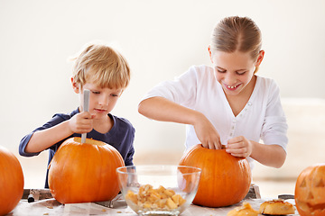 Image showing Sister, brother or happy with pumpkin for halloween, celebration or decoration in kitchen of apartment or home. Family, face or smile and vegetable for preparation, holiday or creative event in house