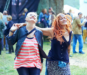 Image showing Woman, friends and music festival for dancing party at outdoor event for listen live band, entertainment in park. Female people, crowd and stage for weekend rave for fun holiday, concert in nature