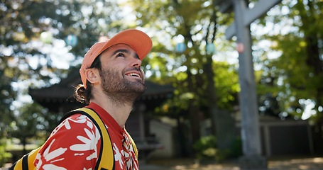 Image showing Outdoor, thinking and man with a smile, travel and nature with sunshine, Japan and tourism. Person, park and guy with happiness, vacation and adventure with journey, getaway trip and exploration