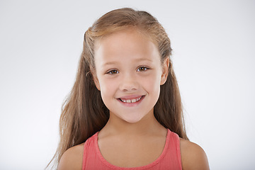 Image showing Child, girl and portrait or happiness in studio with confidence, positive attitude and carefree youth. Kid, face and smile with calm expression, mock up space and casual outfit on white background