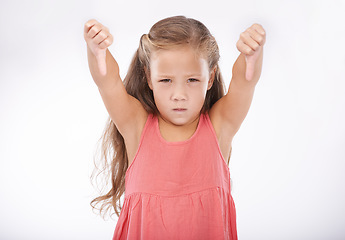 Image showing Thumbs down, girl or portrait of kid in studio for bad news, unhappy emoji sign and vote no on white background. Disappointed child, negative review and fail for decision, wrong results and rejection