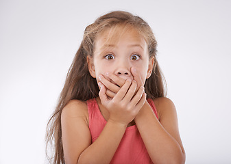 Image showing Shock, portrait and hands over mouth, girl kid with reaction and unexpected news with surprise on white background. Announcement, alarm and youth in studio with facial expression and wow for drama