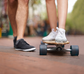 Image showing Skateboard, learning and legs of couple of friends teaching partner skills, riding lesson or practice moving. Skate shoes, sneakers and closeup person coaching, help or support balance on ground