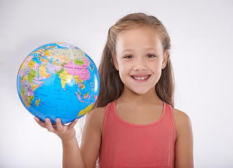 Image showing Girl, child and globe with map for travel, smile in portrait for geography, international and toys on white background. Learning of world, education and development, adventure and student in studio