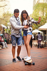 Image showing Skateboard ride, happy and couple teaching girlfriend how to balance, exercise lesson or training in urban Spain. Skate, fun and skateboarder helping, coaching and smile for skateboarding development