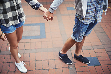 Image showing Legs, walking and couple holding hands on relax journey, morning trip and weekend tour for outdoor adventure. Love, ground and romantic people commute together on street, road or sidewalk floor