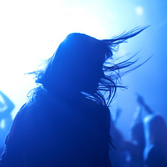 Image showing Person, dancing and crowd or live concert silhouette or music performance or festival, rock or friends. Audience, club and blue lights or celebration rave or band sound as partying, weekend or night