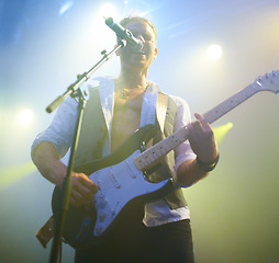 Image showing Man, singing and guitar or crowd at live concert performance for rock, music festival or audience. Male person, instrument and sound for entertainment artist or party show or listen, weekend or event