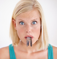 Image showing Portrait, woman and eating tail of fish with surprise and shock on white background of studio. Crazy, diet and person with taste of weird seafood, cuisine and disgust for gross or strange food