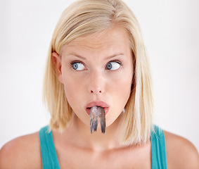 Image showing Face, woman and eating tail of fish with surprise and shock on white background of studio. Crazy, diet and person with taste of weird seafood, cuisine and confused with gross or strange food in mouth