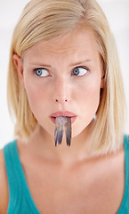Image showing Face, woman and confused with eating fish, tail and surprise on white background of studio. Crazy, diet and person with doubt in weird seafood, cuisine and taste gross or strange food in mouth