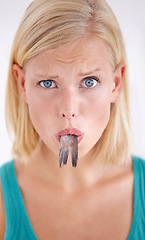 Image showing Confused, woman and portrait eating fish, tail and surprise on white background of studio. Crazy, diet and person with doubt in weird seafood, cuisine and taste gross or strange food in mouth