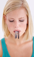 Image showing Woman, face and eating tail of fish with surprise on white background, studio or mockup. Crazy, diet and person with doubt in weird seafood, cuisine and taste gross tuna or strange food in mouth