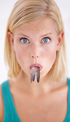 Image showing Eating, fish and portrait of woman with surprise and tail in mouth on white background of studio. Crazy, diet and hungry person with weird cuisine and seafood for sushil, nutrition and shocked face