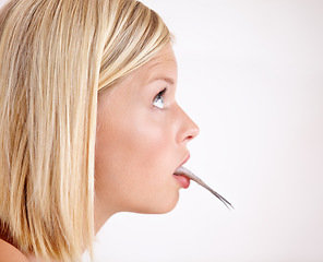 Image showing Profile of woman with fish in mouth in studio with shock, healthy food and omega 3 supplements. Surprise, taste and girl eating whole sardine, benefits of oil in diet and vitamin on white background