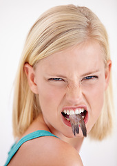 Image showing Woman, eating and portrait with fish, tail or dislike strange food in mouth on white background of studio. Crazy, diet and person with weird seafood, cuisine and disgust for taste of tuna or salmon