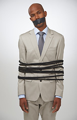 Image showing Portrait, business and black man tied with rope, mouth covered with tape and compliance issue on white studio background. African person, employee or entrepreneur with control, policy or crisis