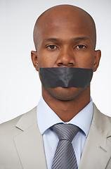 Image showing Portrait, business and tape with black man, mouth covered and employee on white studio background. Face, African person or censored with secrets, silence or confidential with entrepreneur and worker