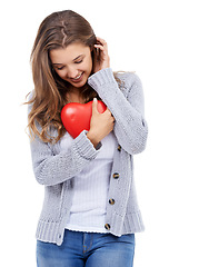 Image showing Red heart, smile and shy woman in studio for love, care and romance, affection or support on white background. Shape, flirt and female model with symbol, sign or icon for valentines day celebration