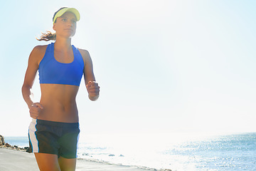 Image showing Fitness, beach and young woman running for race, competition or marathon training exercise. Sports, health and female athlete runner with cardio workout for endurance and speed by ocean or sea.