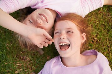 Image showing Grass, happy kids or sisters laughing in park for bond, holiday or play together for support or joy. Top view, relax or funny children siblings in field with smile, love or friendship in a garden