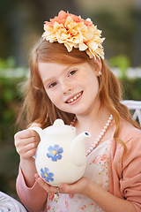 Image showing Girl, child and tea or happy in garden with party for birthday, celebration and playing outdoor in home. Person, portrait and face in backyard of house with dress up, beverage and role play fun