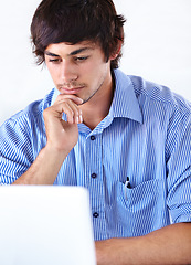 Image showing Man, working and thinking with laptop, face and studio background for company, employee and digital. Agency, internet and online for email, young or technology with news, job or reading for business