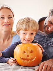 Image showing Family, portrait and parents of kid with pumpkin to celebrate halloween, fun and creativity at home. Happy boy child, mom or dad carving face in orange vegetable, holiday lantern and party decoration
