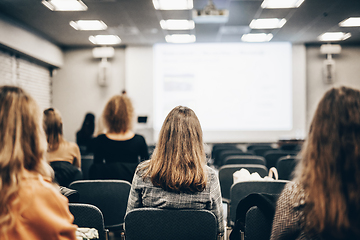 Image showing Speaker giving a talk in conference hall at business event. Rear view of unrecognizable people in audience at the conference hall. Business and entrepreneurship concept.