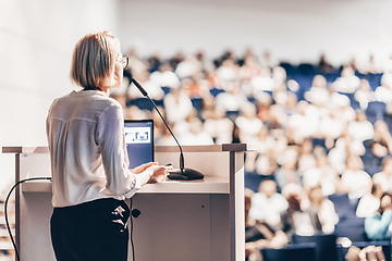 Image showing Female speaker giving a talk on corporate business conference. Unrecognizable people in audience at conference hall. Business and Entrepreneurship event.