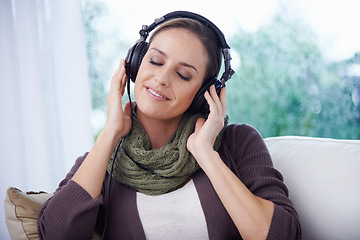 Image showing Home, relax and woman with headphones, listening to radio and peaceful with weekend break and calm. Apartment, podcast and person on sofa and headset for audio, sound and streaming music with joy