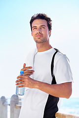 Image showing Beach, thinking and man with water bottle, fitness and exercise with wellness and sunshine. Person, seaside and guy with liquid and ideas with nature, summer and workout with breathing and nutrition