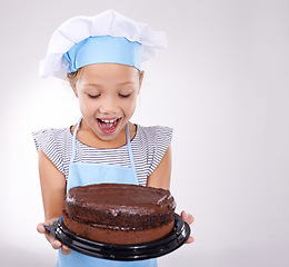 Image showing Kid, baker and excited with cake, happy and confident with child development on white background. Culinary skills, satisfied and baking dessert and childhood with confidence in hospitality industry