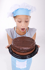 Image showing Kid, baker and shocked with cake, happy and confident with child development on white background. Culinary skills, satisfied and baking dessert and childhood with confidence in hospitality industry