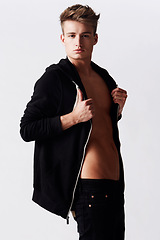 Image showing Portrait, hoodie and man with body, wellness and confident guy on a white studio background. Person, fashion and model with self care, aesthetic and hygiene with edgy clothes, masculine and attitude