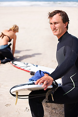 Image showing Thinking, cleaning and man with surfboard on beach for sports, training or getting ready to workout. Summer, vision and wax with confident surfer on sand by ocean or sea for fitness and exercise