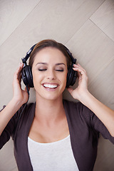 Image showing Woman, relax with headphones and top view, listening to music with smile at home, album or playlist online. Podcast, radio and audio streaming, happiness with technology and peace with eyes closed