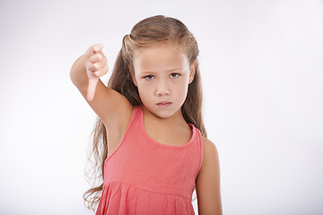 Image showing Thumbs down, child or portrait of girl in studio for bad news, emoji sign and vote no for feedback on white background. Unhappy kid, negative review or failure of decision, wrong results or rejection