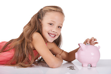 Image showing Girl child, piggy bank and coins for portrait, studio and pride with smile for investing by white background. Kid, container or animal toys with relax for money, cash or happy for financial education
