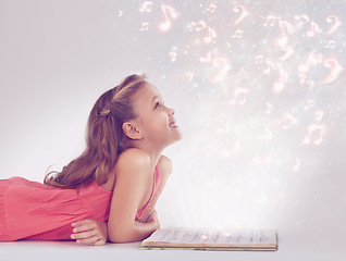 Image showing Child, book and magic fantasy or dream for music listen or storytelling creativity, sound or imagination. Female person, kid and whimsical notes or white background in studio, supernatural or mockup