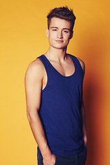 Image showing Portrait, fashion and man with style, student and confident guy on an orange studio background. Face, person and model with joy, casual outfit and stylish clothes with gen z, trendy and aesthetic