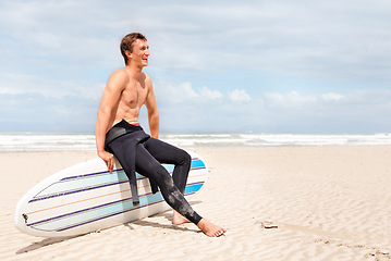 Image showing Thinking, beach and shirtless man with surfboard on space in wetsuit for sports, travel or fitness. Nature, vision and body of young surfer laughing with sand by ocean for exercise on blue sky