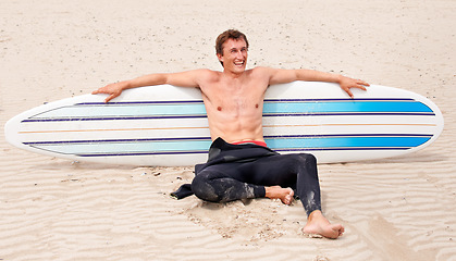 Image showing Relax, vision and laughing man with surfboard on beach in wetsuit for sports, travel or fitness. Thinking, smile and body of young surfer on sand by ocean or sea for break from training and exercise
