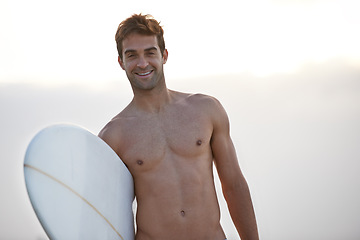 Image showing Fitness, portrait and happy man at a beach with surfboard for wellness, sports and training in nature. Water, exercise and face of male surfer at the ocean for morning cardio, freedom and travel