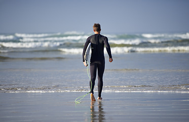 Image showing Ocean, surfing and man with surfboard at beach for waves on summer vacation, weekend and holiday by sea. Travel, nature and back of person running for water sports, adventure and hobby in Australia